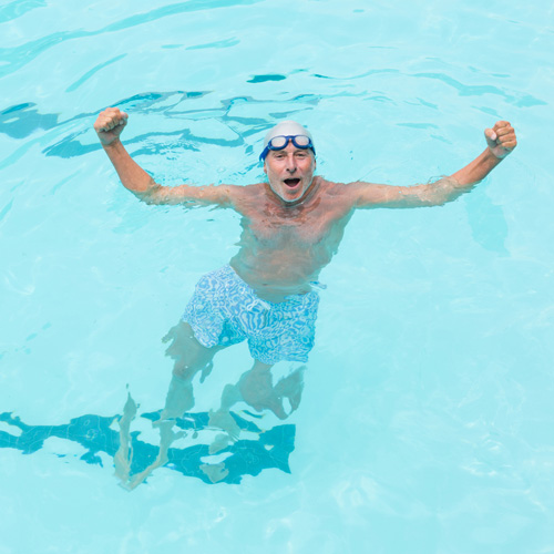 Man swimming in a pool with raised arms