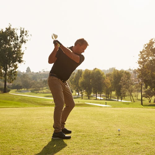 Middle-aged man swinging a golf club