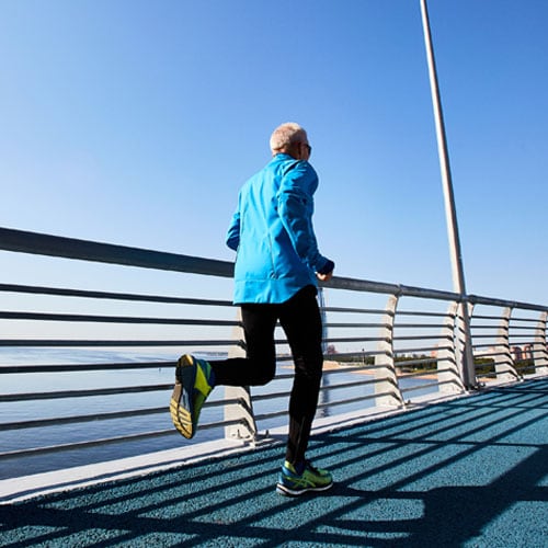 Mature active man running on an urban path