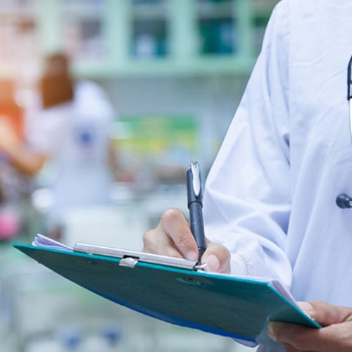 Medical professional writing on a clipboard